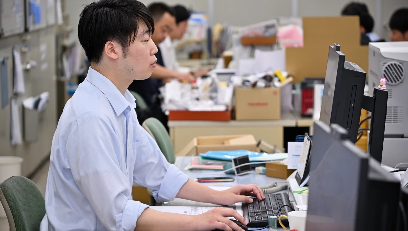 デスクワークをする管理部副主任H.S