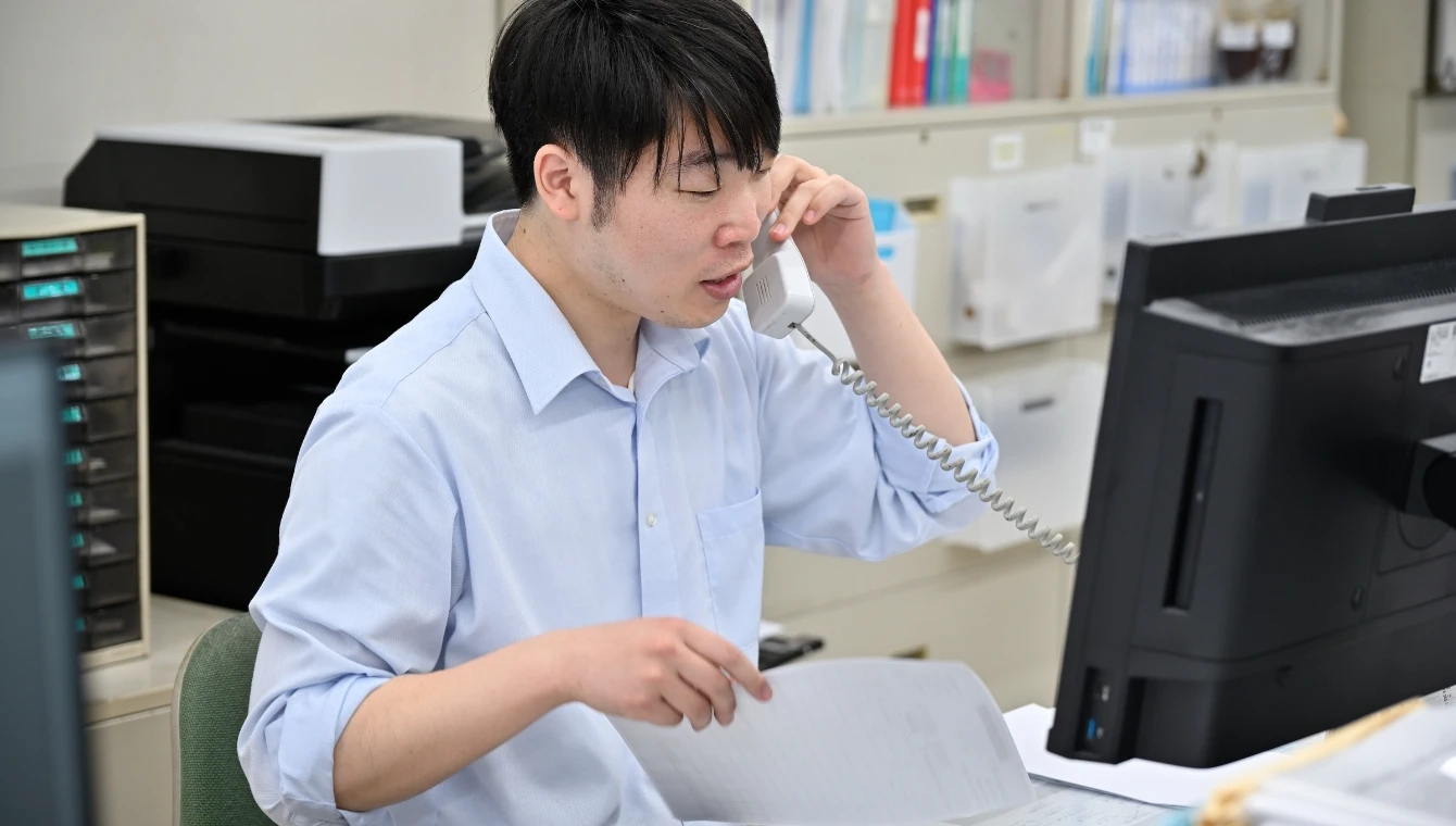 電話対応をする管理部副主任H.S